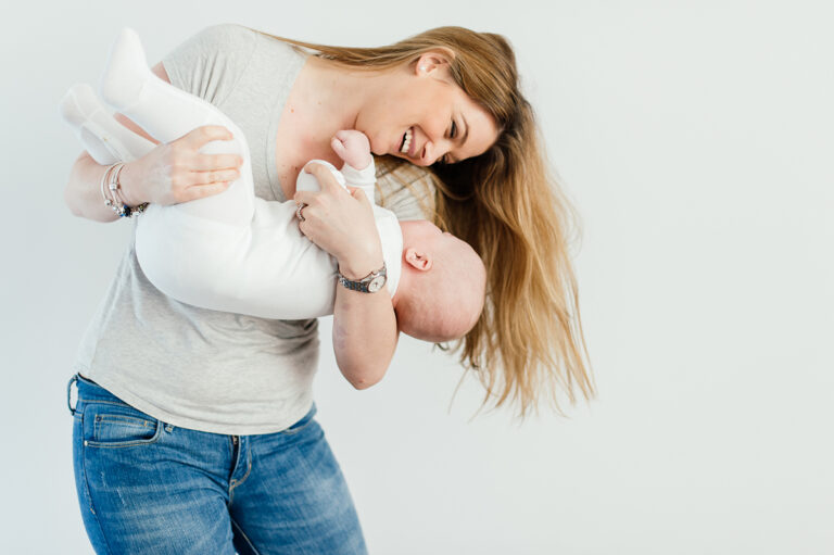 Woman holding baby and smiling